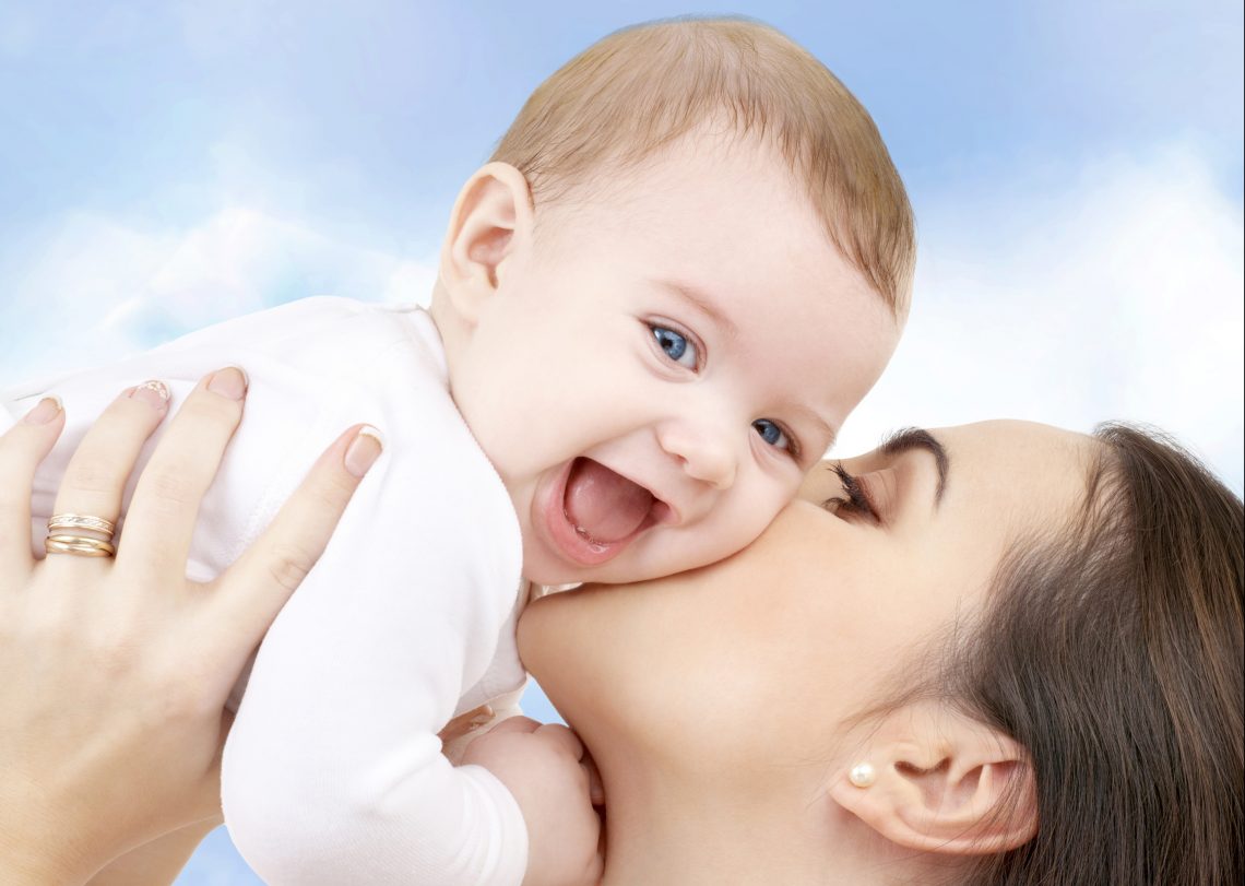 laughing baby playing with mother