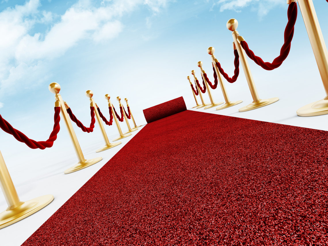 Rolled red carpet and velvet ropes