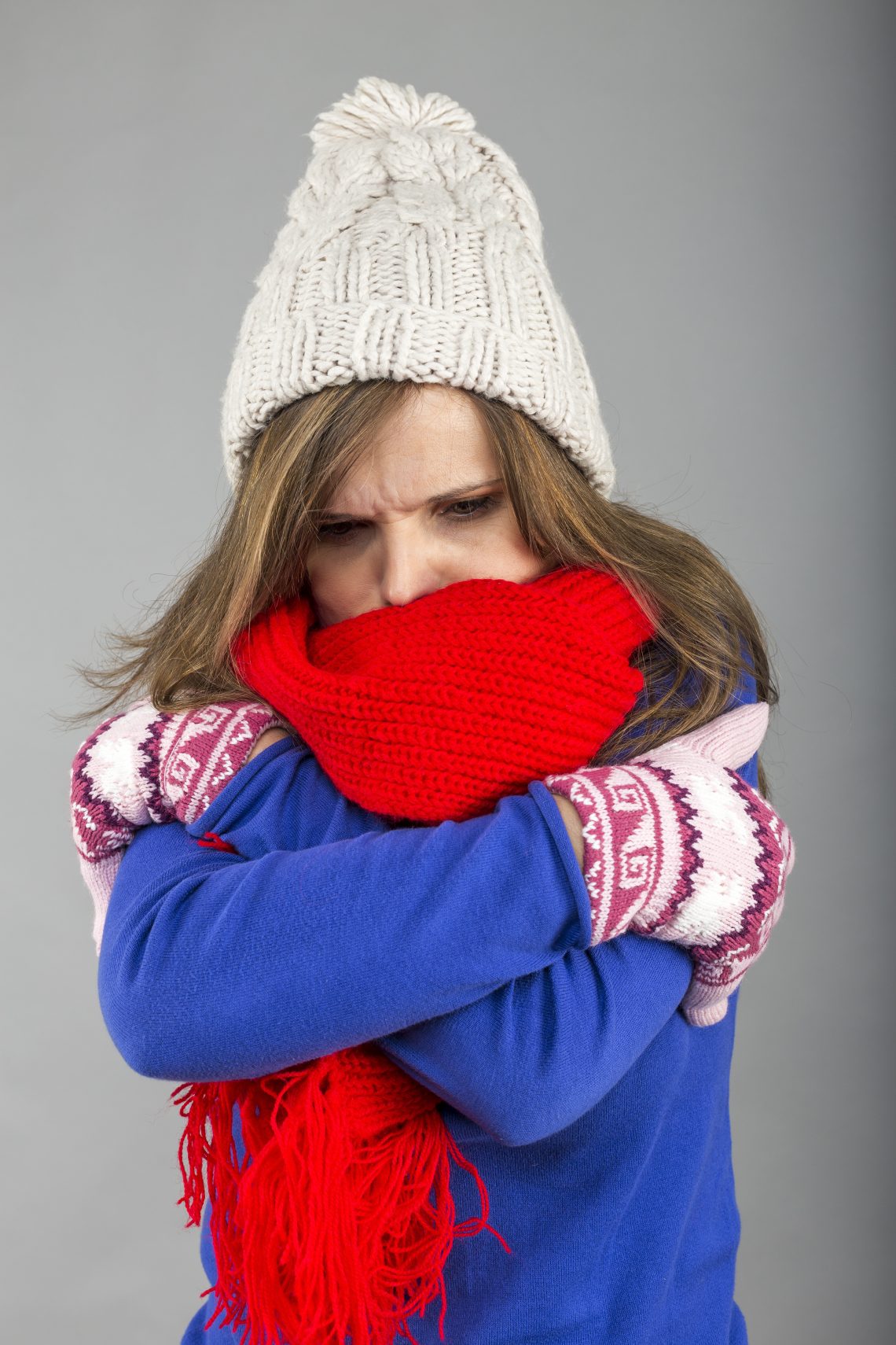 Young woman feeling cold trying to keep warm, shaking and shive