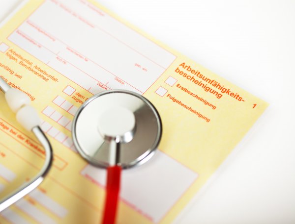 close up of a german paper for the Health insurance In case of illness with a stethoscope