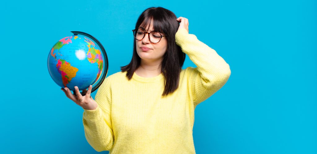 WHO-Bericht zu Übergewicht in Europa: Eine übergewichtige junge Frau blickt skeptisch auf einen Globus in ihrer Hand