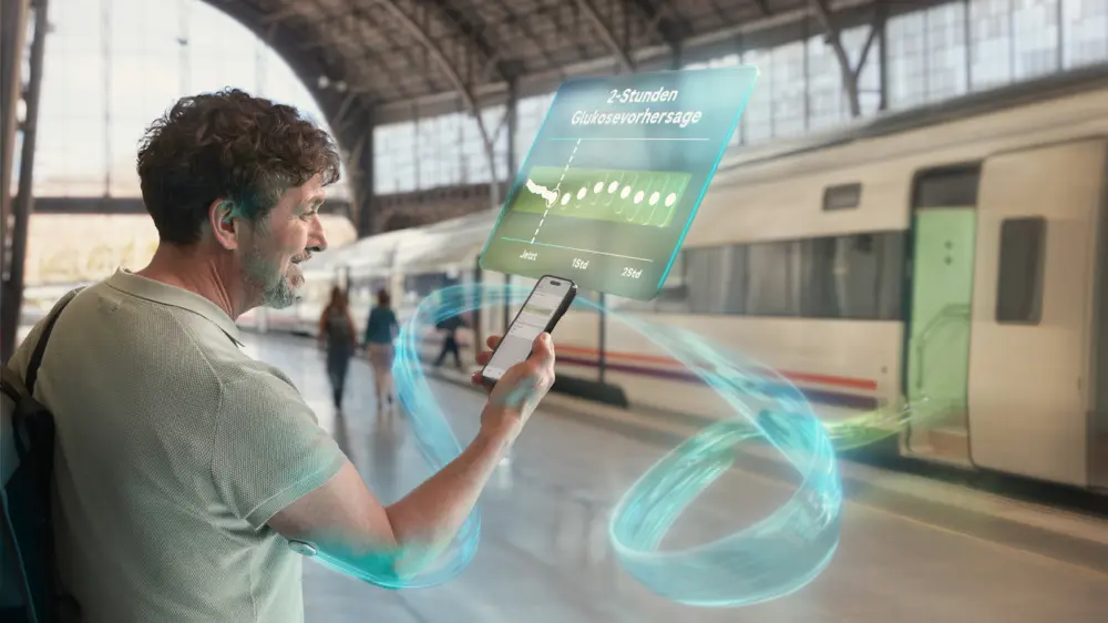 Mann ruft am Bahnhof mit seinem Smartphone Glukosedaten ab