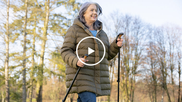 Eine Frau lauft mit Walking-Stöcken durch den Wald