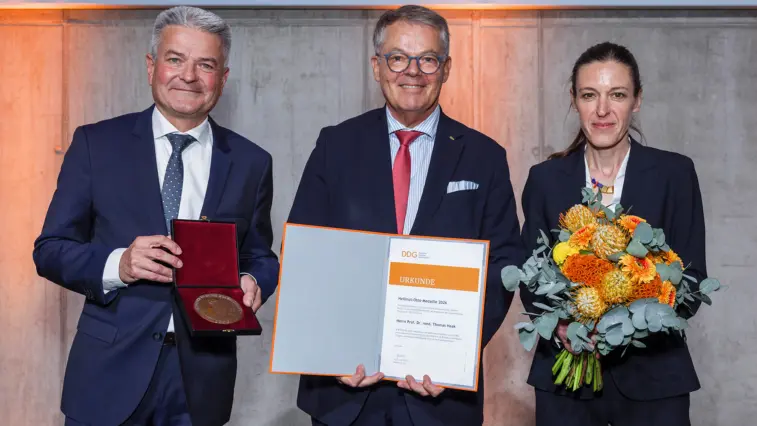 Prof. Dr. Thomas Haak (Mitte) präsentiert gemeinsam mit Prof. Dr. Andreas Seufert (links) und Prof. Dr. Barbara Ludwig seine Urkunde und die Hellmut-Otto-Medaille der Deutschen Diabetes Gesellschaft. Prof. Haak hält zudem die geöffnete Medaillenbox, Prof. Ludwig einen Blumenstrauß.