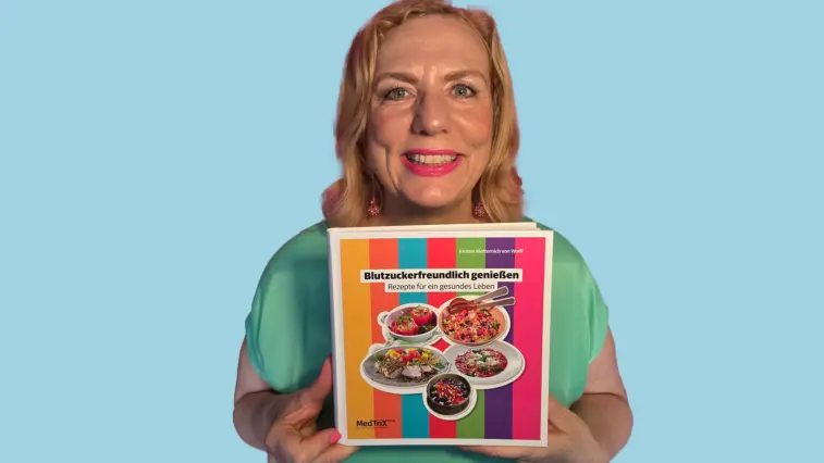 Ernährungsexpertin und Diabetes-Anker-Redakteurin Kirsten Mettrnich von Wolff hält lächelnd in die Kamera blickend ihr neues Buch „Blutzuckerfreundlich genießen – Rezept für ein gesundes Leben“ in den Händen.