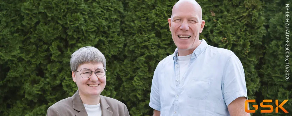 Dr. med. Katrin Kraatz (links) und Dr. med. Dietrich Tews stehen lächelnd vor einer grünen Hecke.