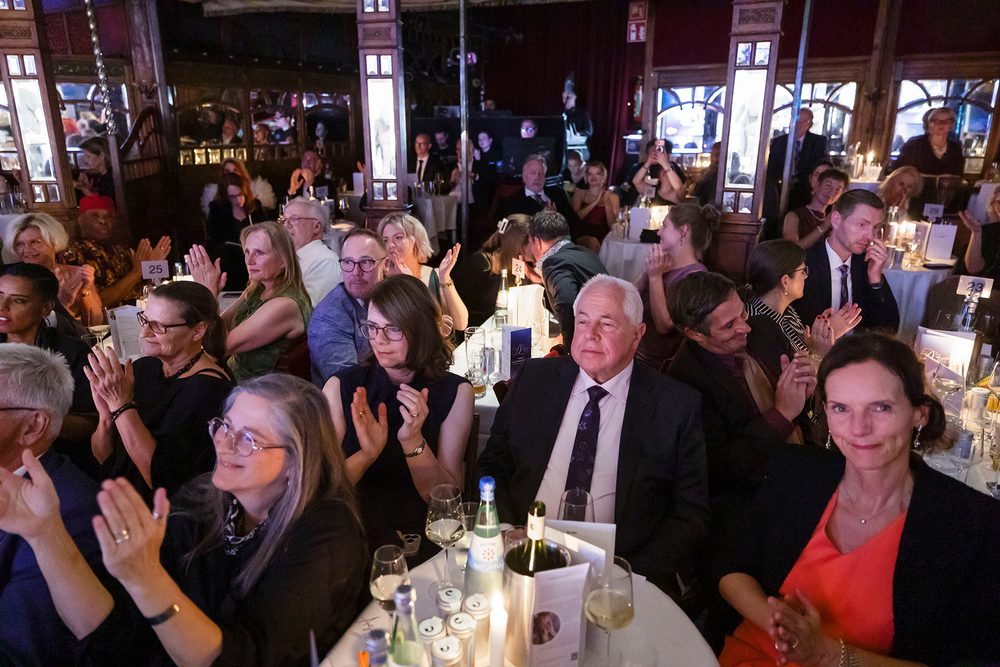 Gäste an festlich gedeckten Tischen applaudieren bei der Diabetes-Charity-Gala; viele blicken zur Bühne.