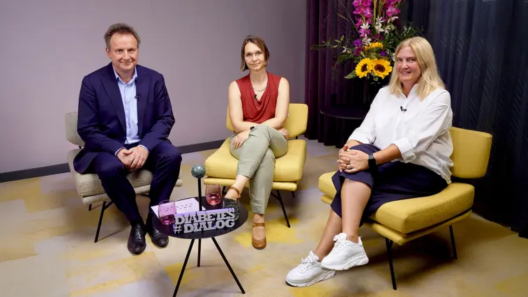 Prof. Dr. Matthias Blüher, Anika Köhler und Heike Schätzle sitzen bei einem Gespräch des „Diabetes-Dialogs“ in Sesseln. Auf dem Tisch steht ein Schild mit dem Sendungstitel; im Hintergrund ist ein Blumenarrangement zu sehen.