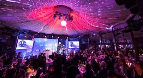 Bei der 15. Diabetes-Charity-Gala in der Berliner „Bar jeder Vernunft“ tritt Georg Stengel auf. Das Publikum sitzt an Tischen vor der violett und pink beleuchteten Bühne.