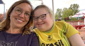 Selfie von Diabetesberaterin Doreen Haberkorn und einem lächelnden Mädchen in einem gelben Brasilien-Trikot auf einem Jahrmarkt, im Hintergrund Fahrgeschäfte und Bäume.