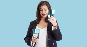 Eine Frau vergleicht zwei Gläser mit unterschiedlich hohem Wasserstand und blickt dabei nachdenklich auf das fast volle Glas.