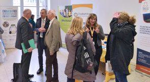 Mehrere Personen im Gespräch an Informationsständen bei einer Diabetes-Veranstaltung, im Hintergrund Roll-ups unter anderem der Diabetiker Baden-Württemberg und der Wieland-Stiftung.